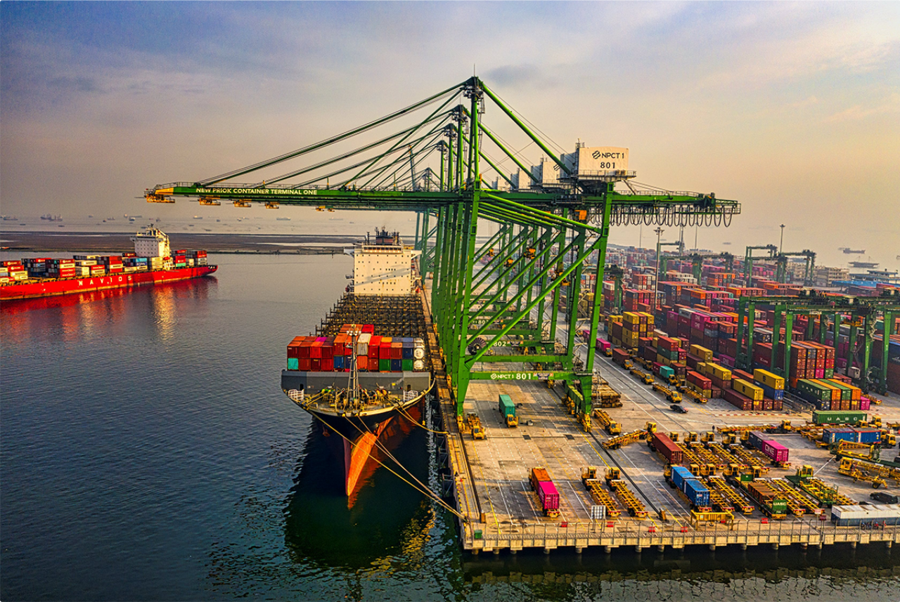 shipping port with green cranes and cargo